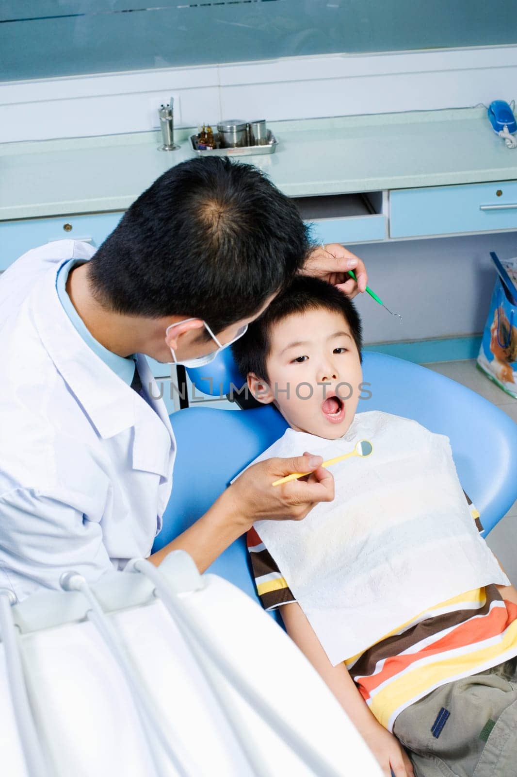 Close-up of a male dentist examining a boyŽs teeth