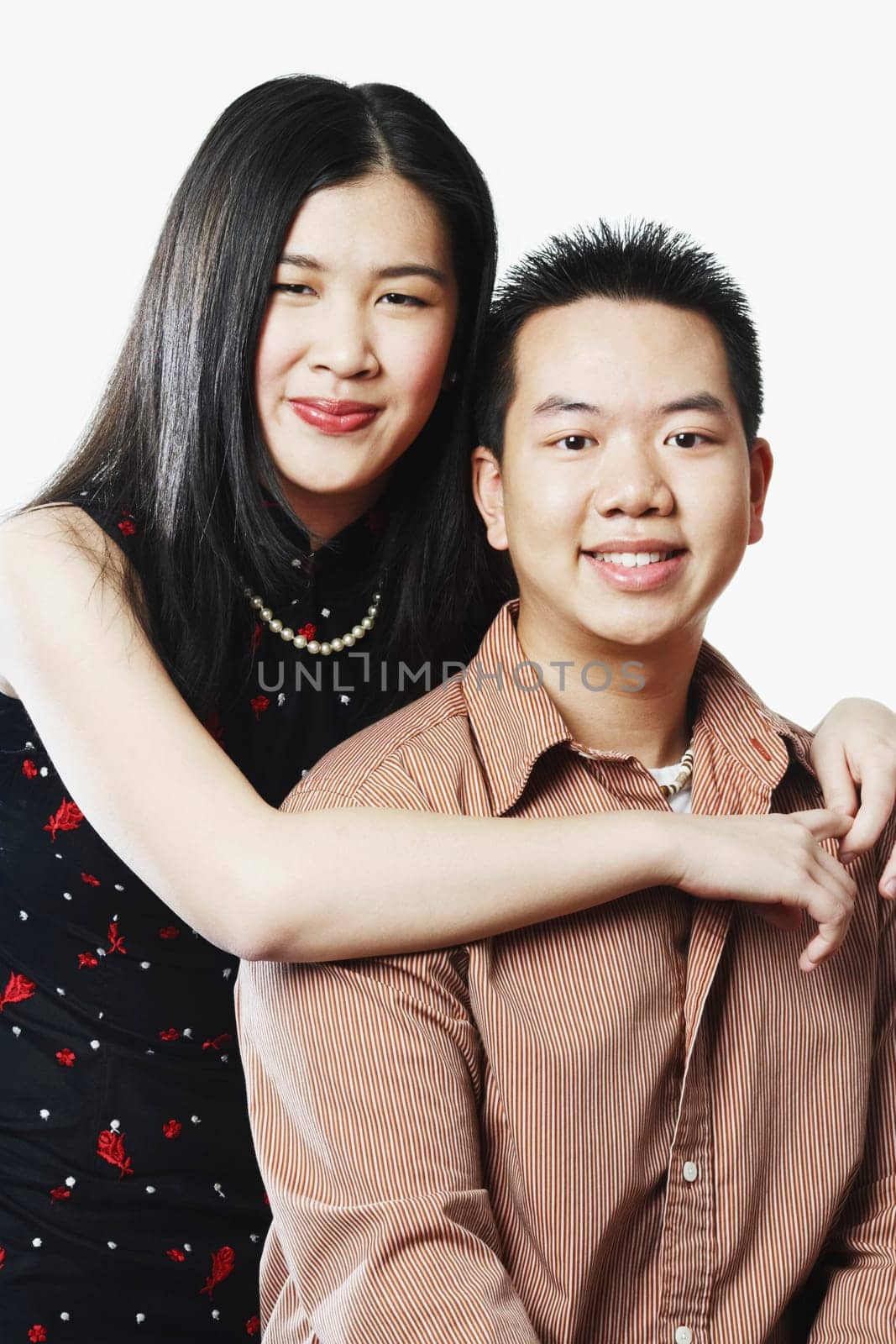 Portrait of a young woman embracing a young man from behind