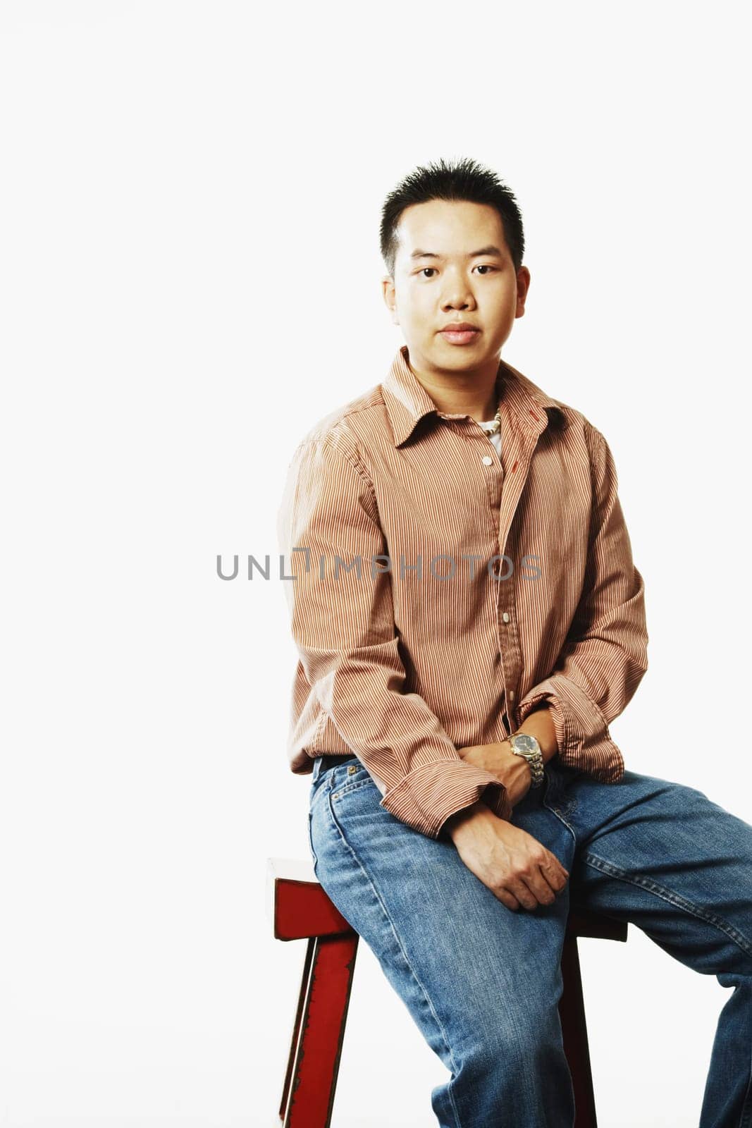 Portrait of a young man sitting on a stool