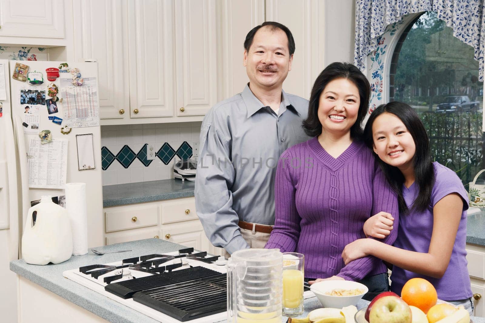 Portrait of a girl and her parents in the kitchen