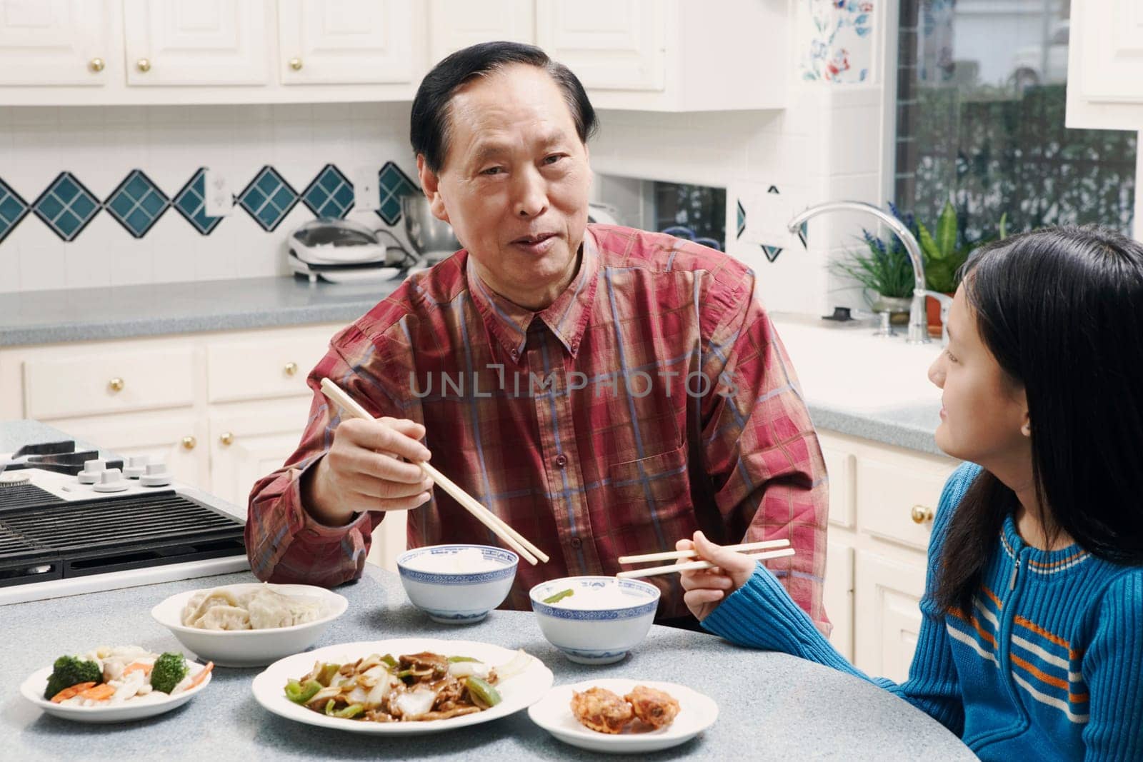 Grandfather and his granddaughter sitting at a table
