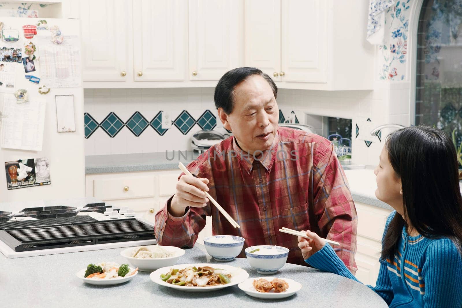 Grandfather and his granddaughter sitting at a table