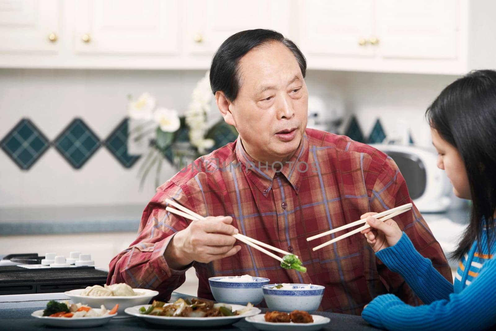Grandfather and his granddaughter sitting at a table