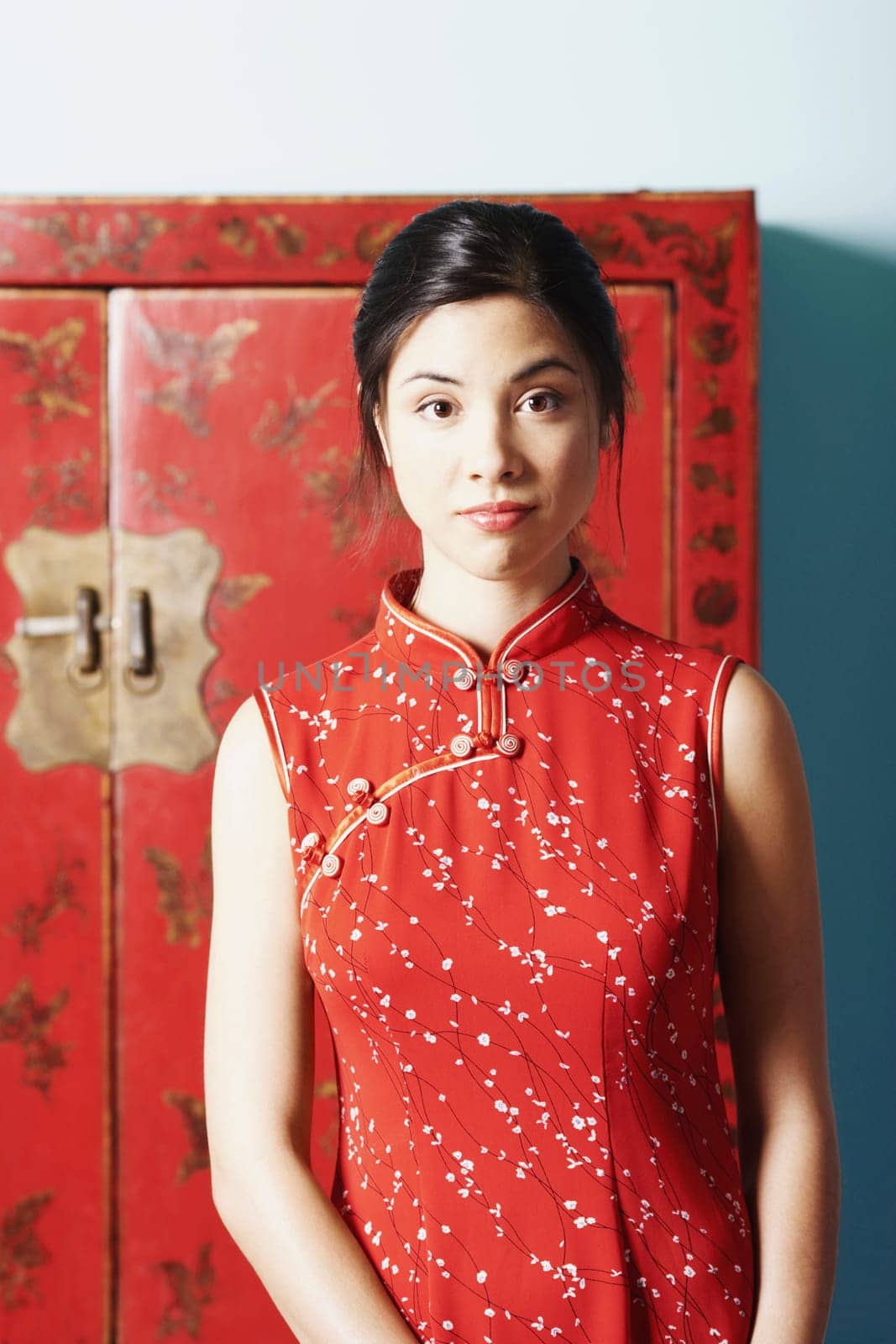 Portrait of a young woman standing in front of a cupboard