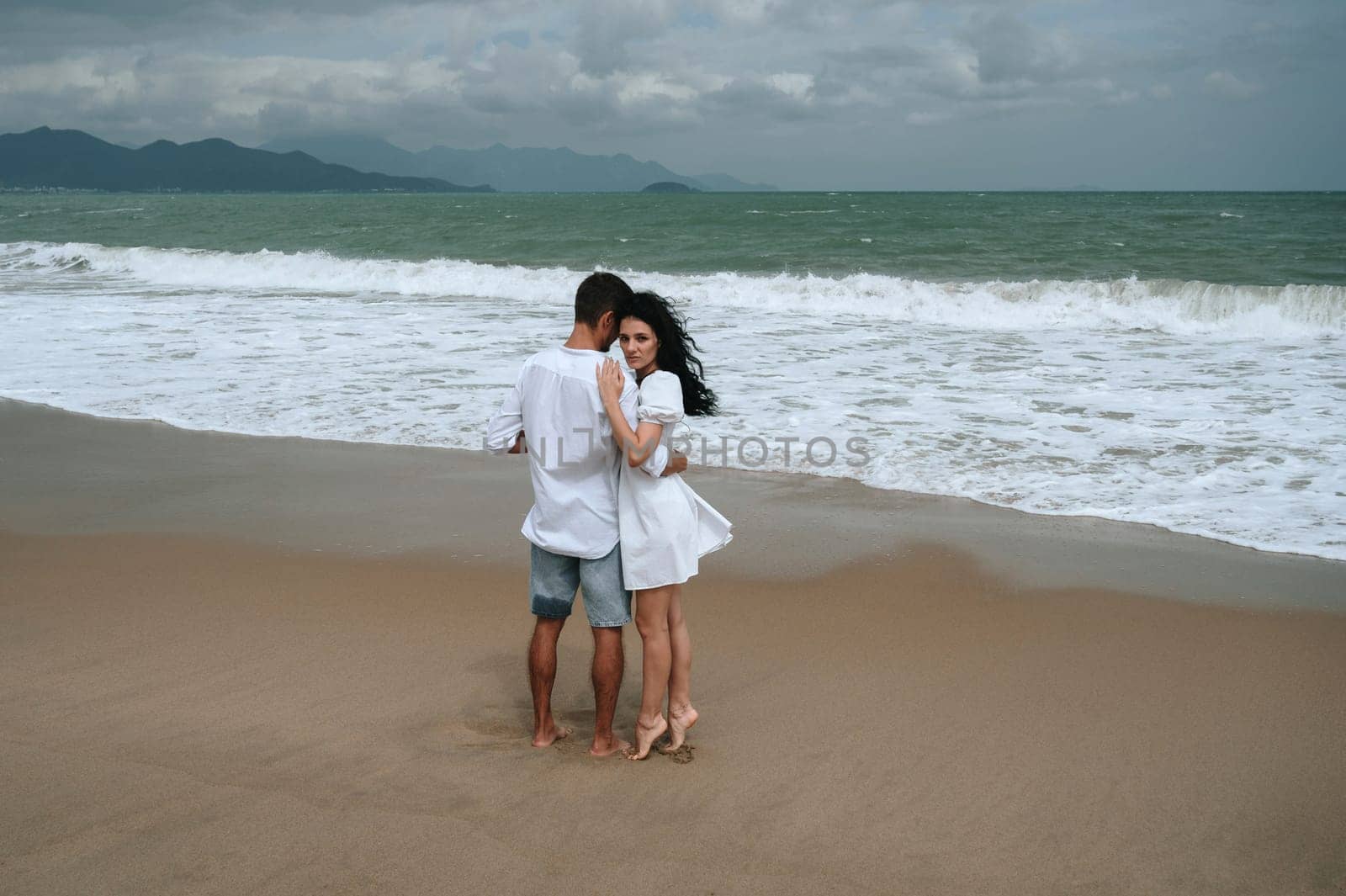 happy couple in love hugs on the beach by the sea in summer on vacation