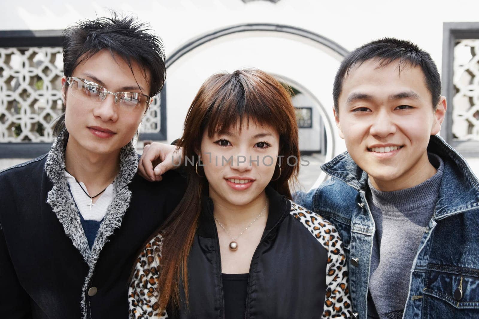 Portrait of a young woman posing with two young men