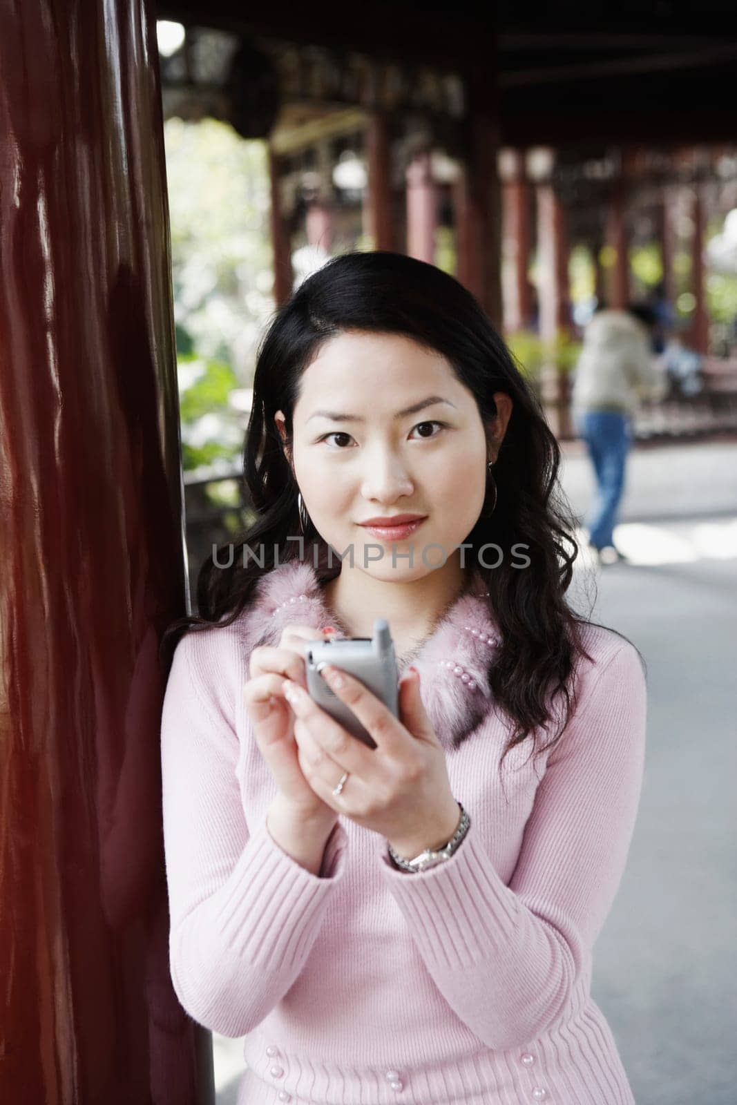 Portrait of a young woman operating a mobile phone with a digitized pen