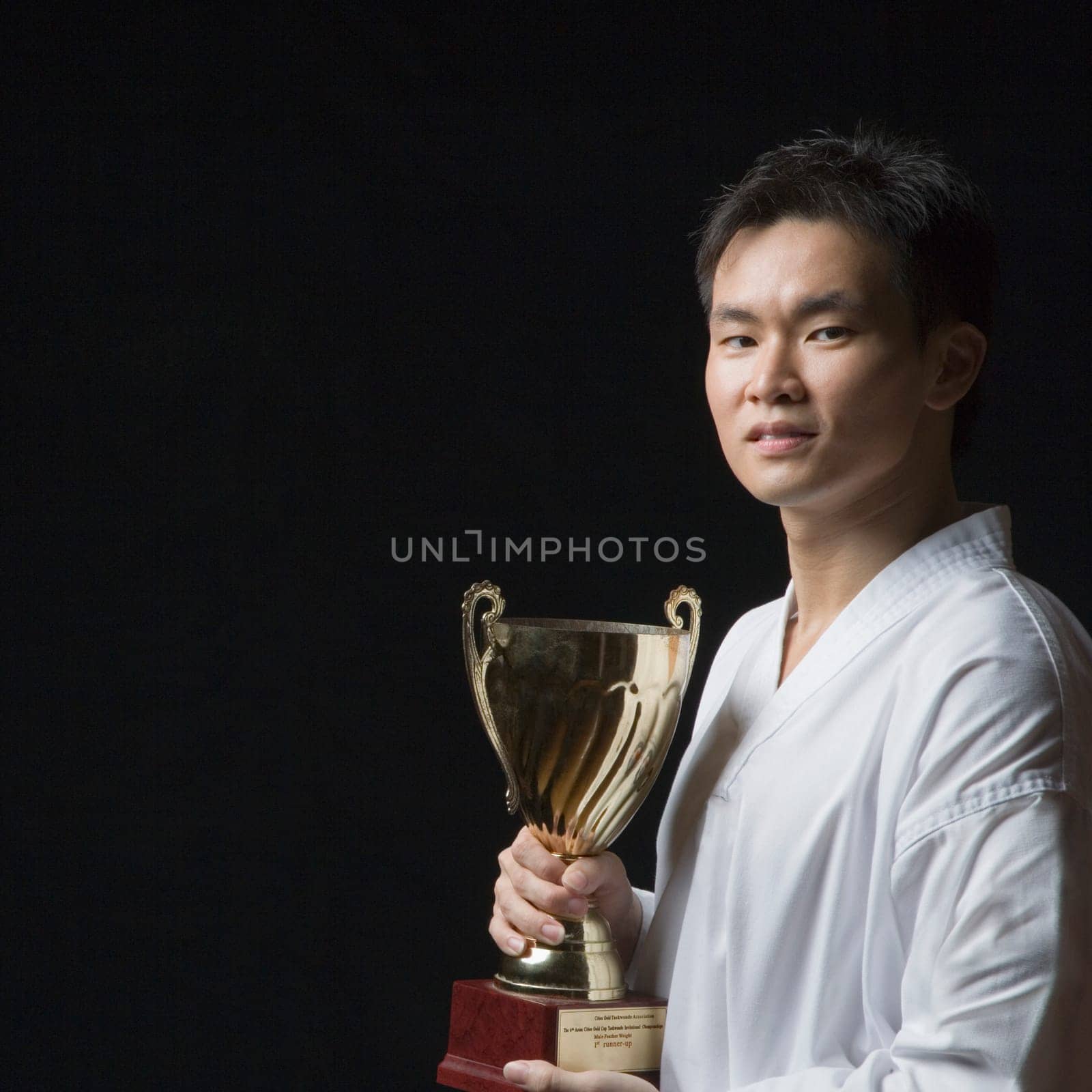 Portrait of a young man holding a trophy