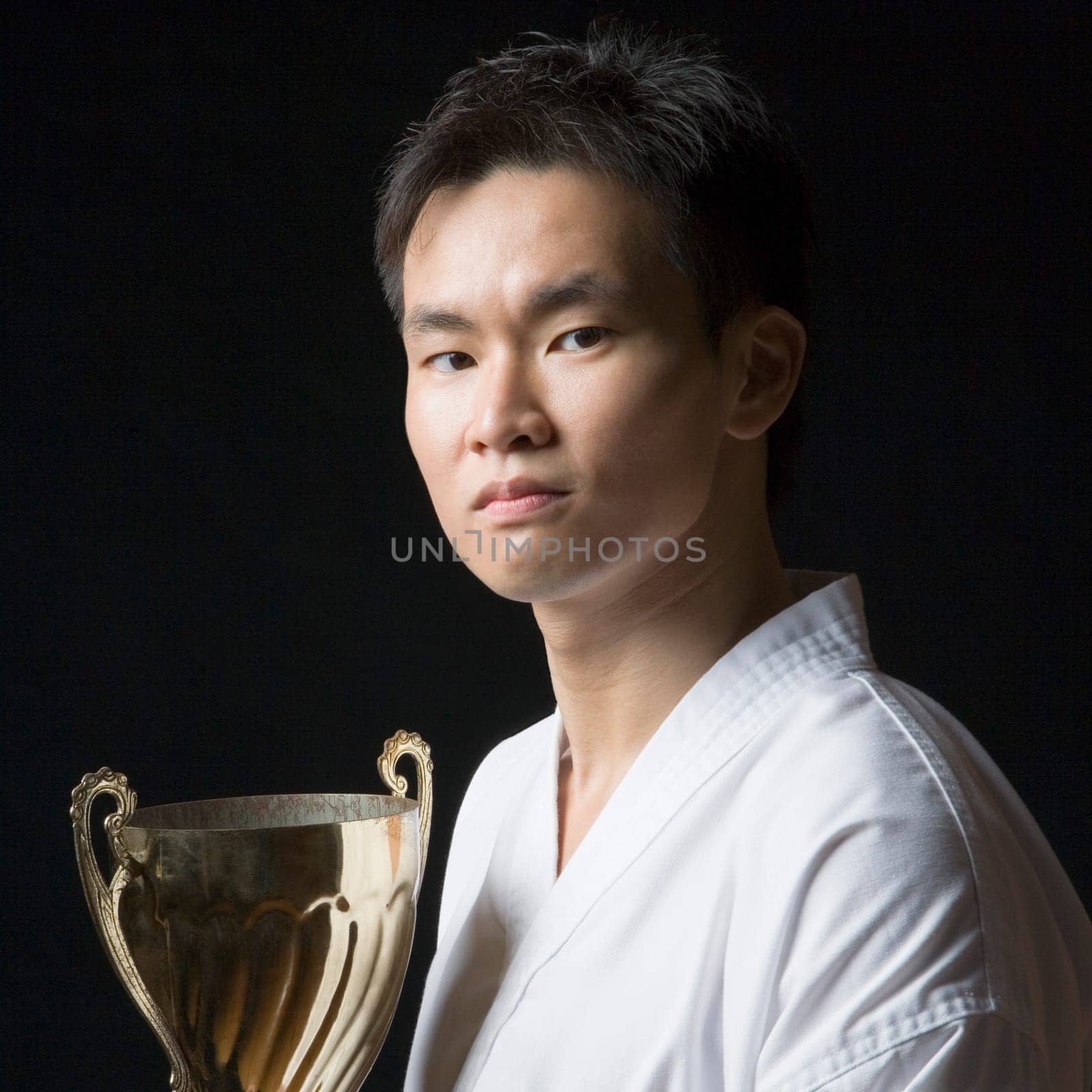Portrait of a young man holding a trophy