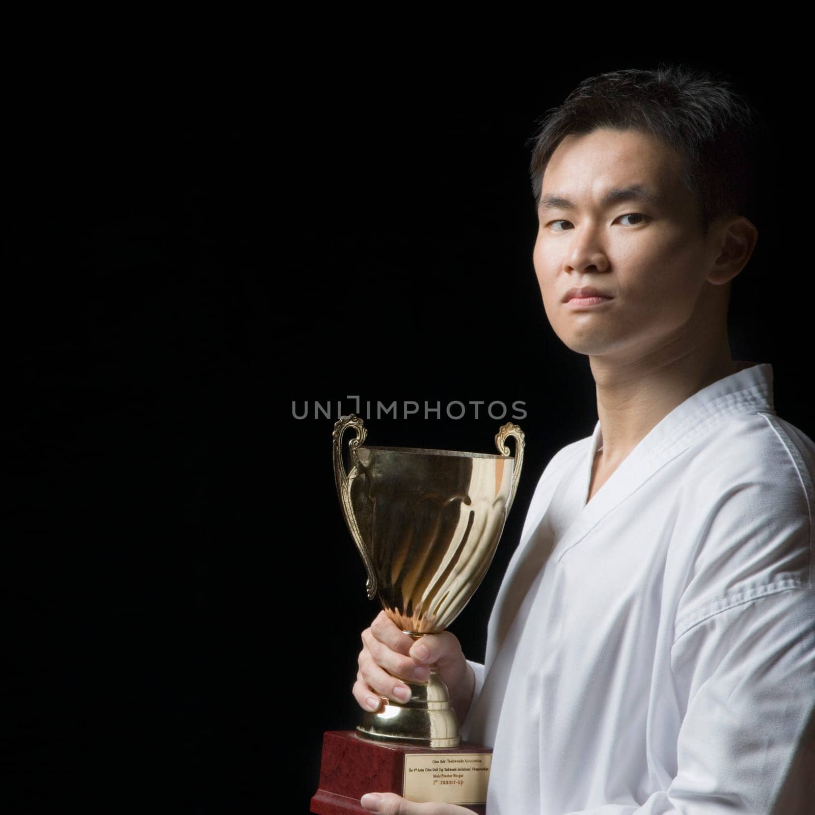Portrait of a young man holding a trophy