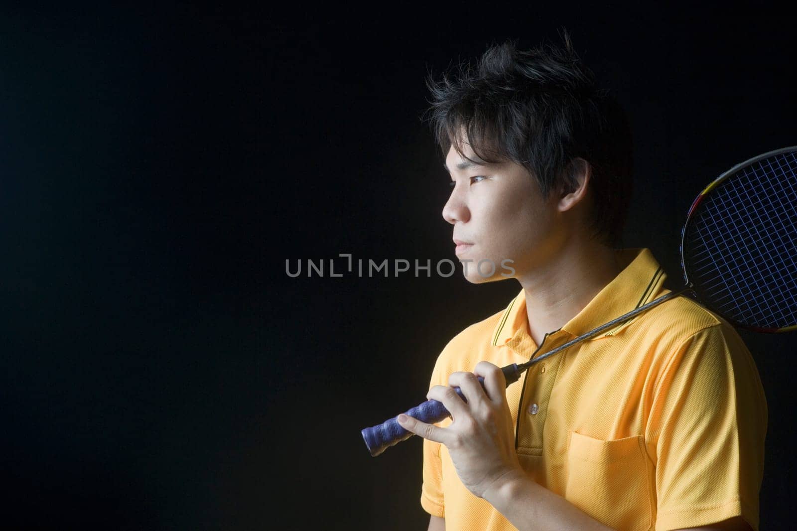 Close-up of a young man holding a badminton racket