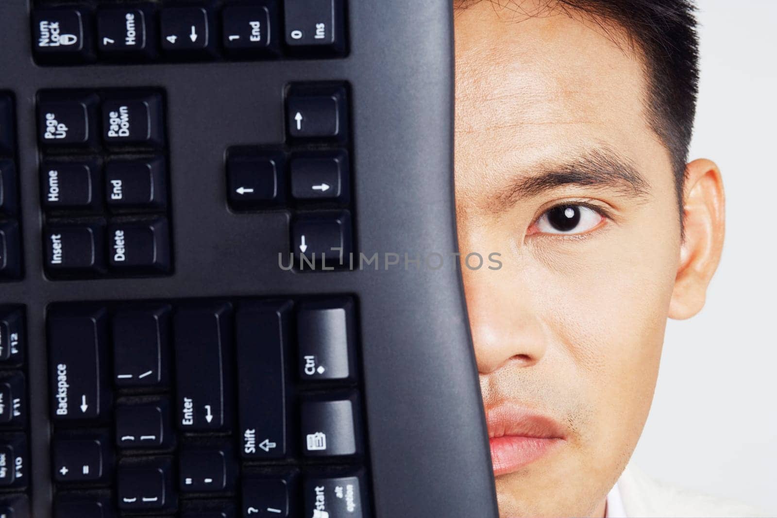 Portrait of a businessman with a computer keyboard in front of his face