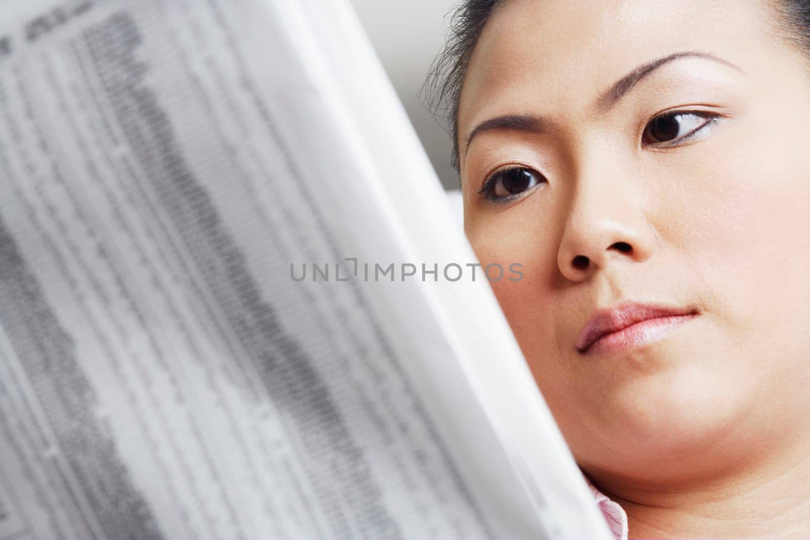 Close-up of a businesswoman reading a financial newspaper