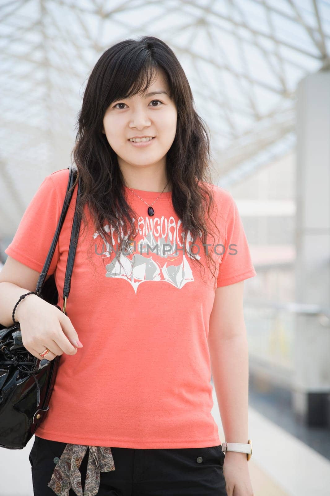 Portrait of a young woman standing in a corridor and smiling