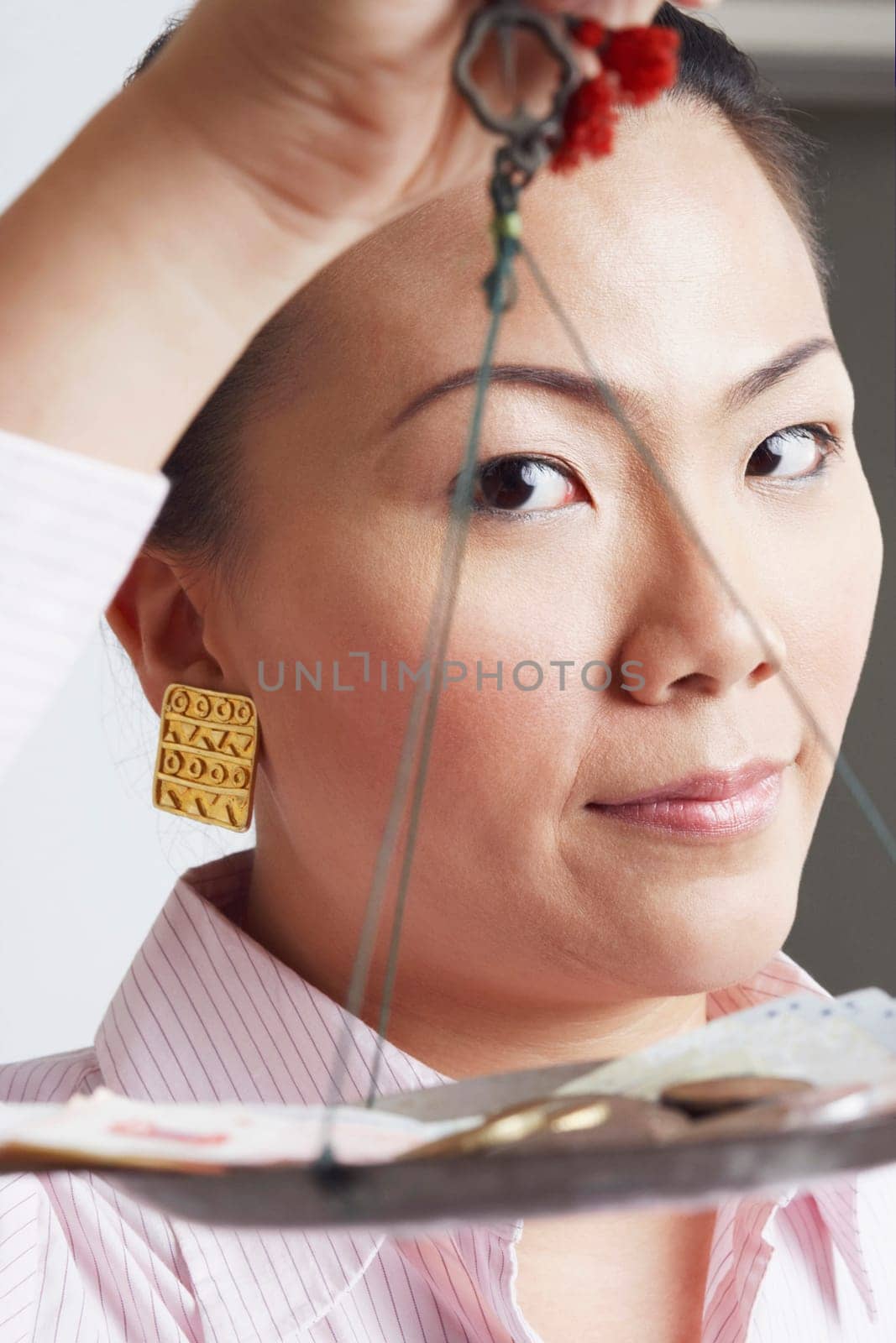 Portrait of a businesswoman weighing paper currency with coins on a weighing scale