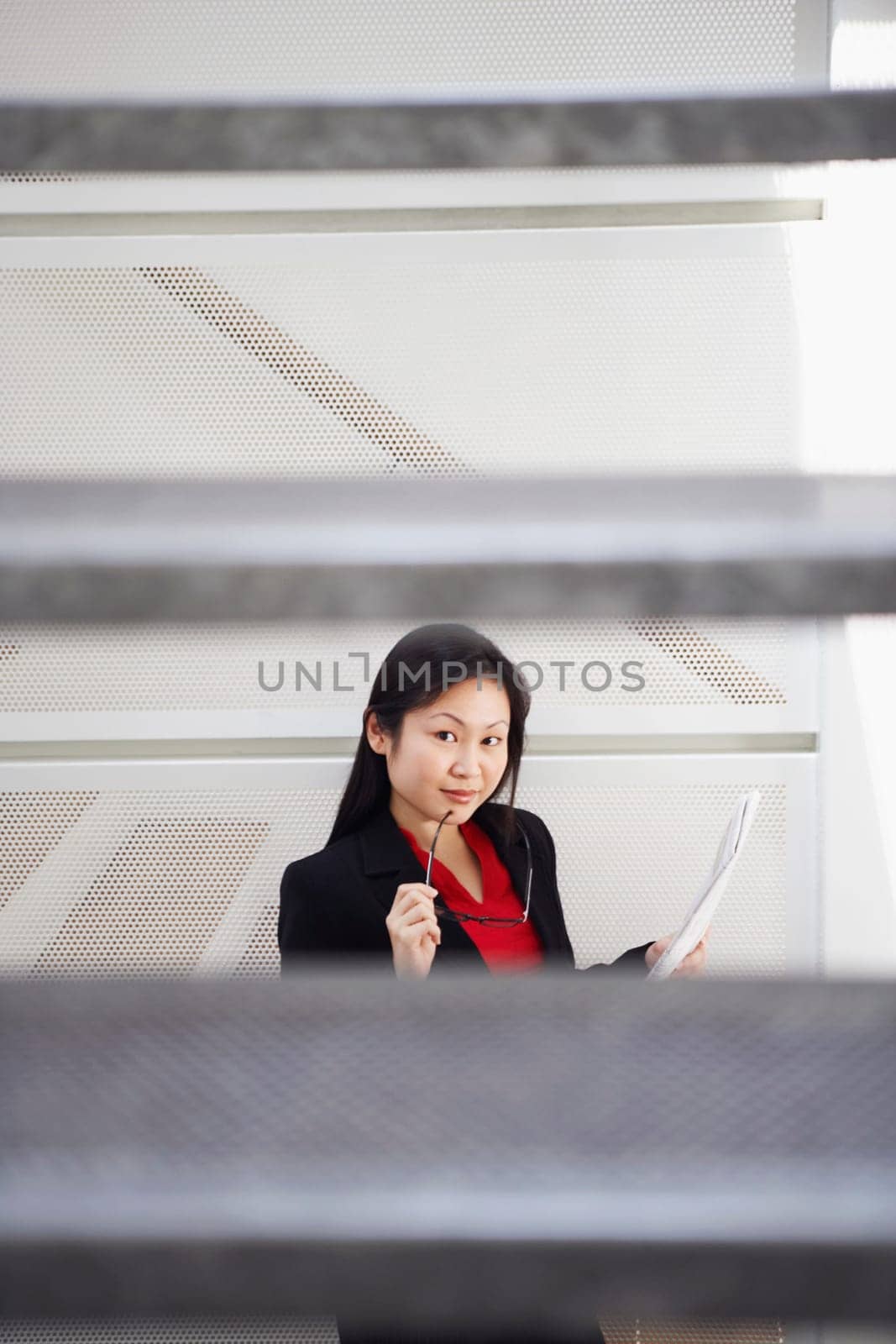 Portrait of a businesswoman holding a newspaper and posing