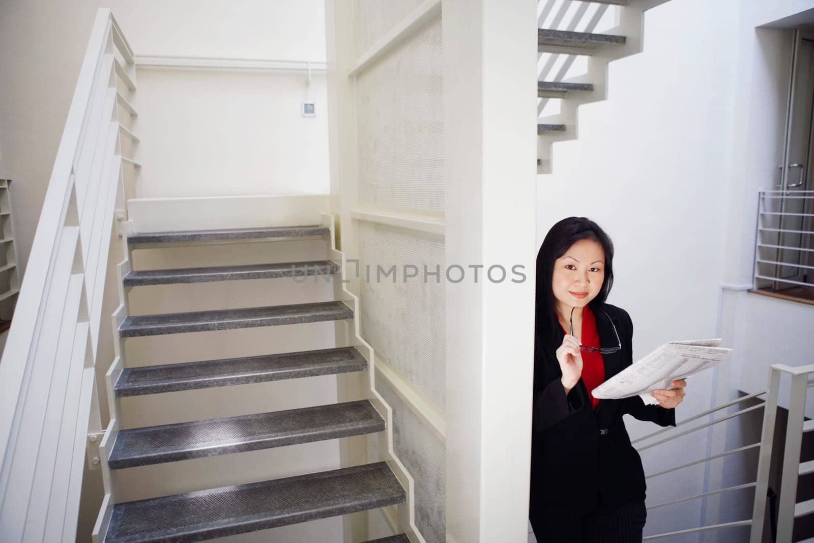 Portrait of a businesswoman holding a newspaper and smiling