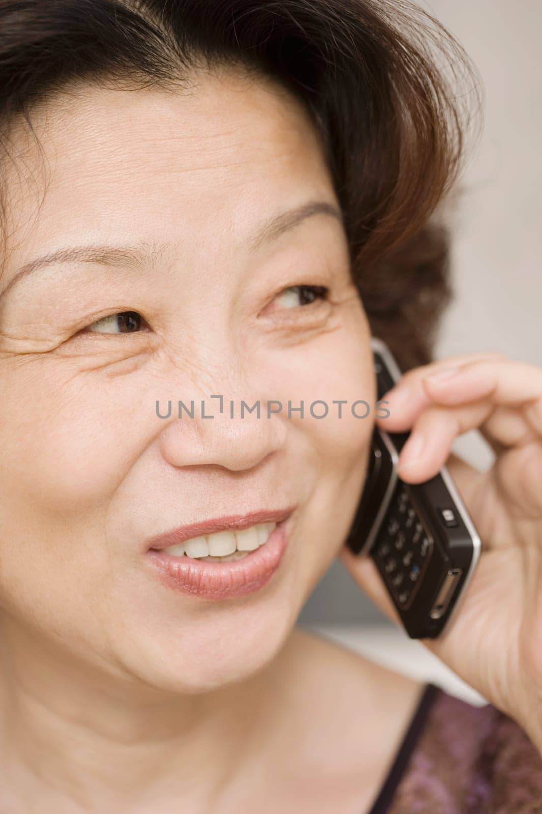 Close-up of a mature woman talking on a mobile phone and smiling