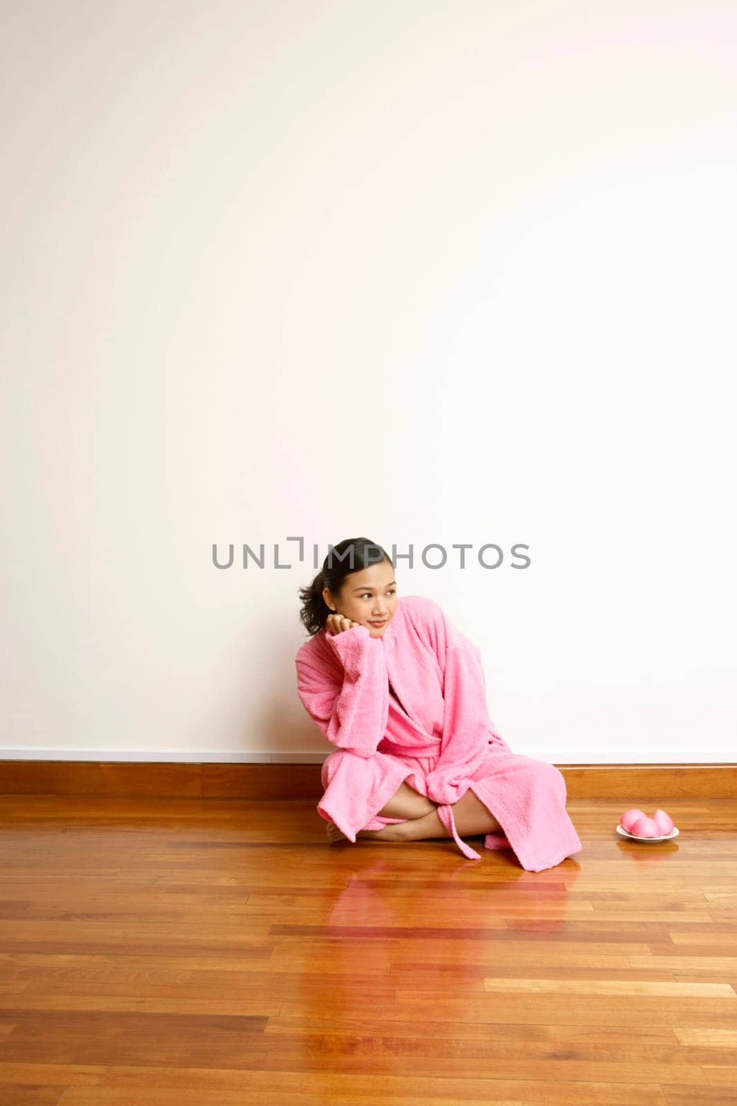 Young woman sitting on a hardwood floor