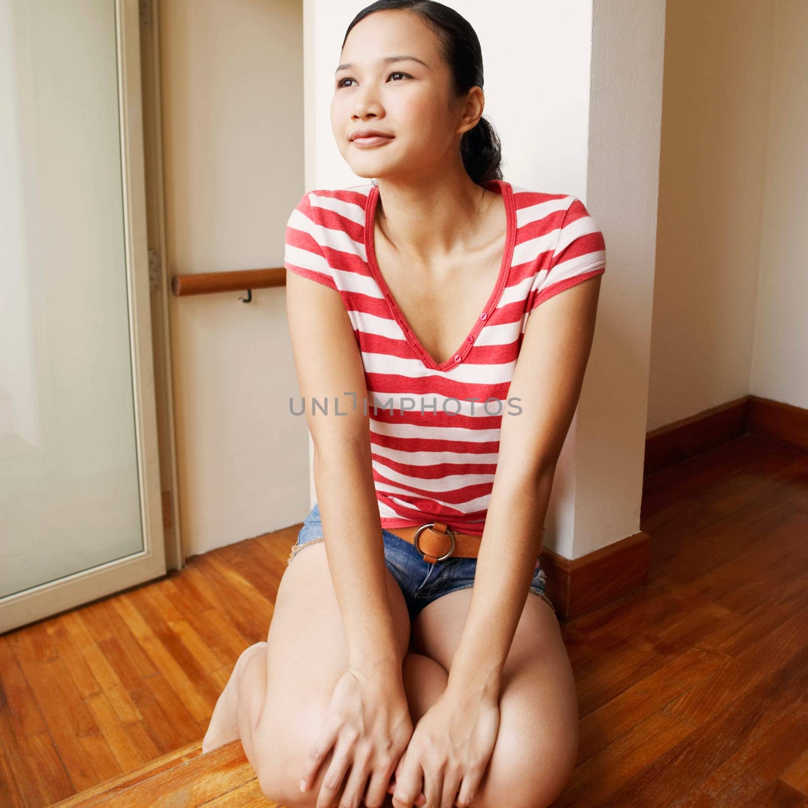 Young woman kneeling on a hardwood floor