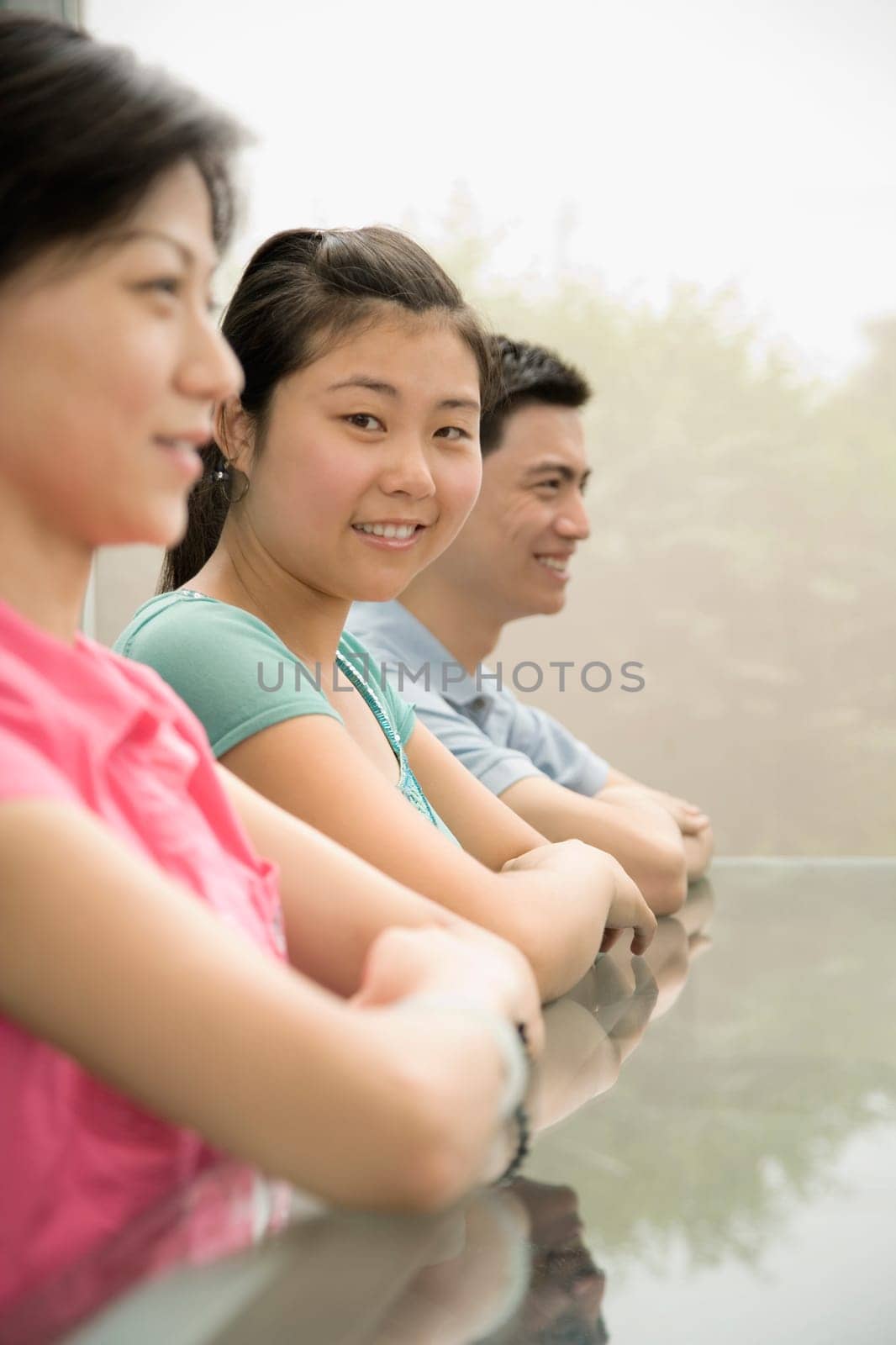 Side profile of three office workers sitting at a conference table