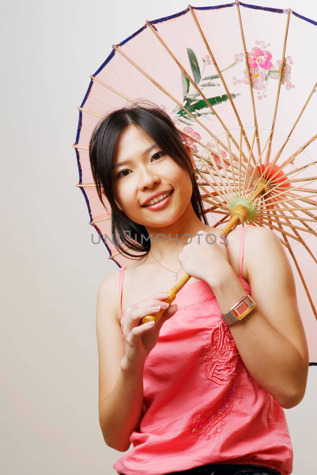 Portrait of a young woman holding a parasol and smiling
