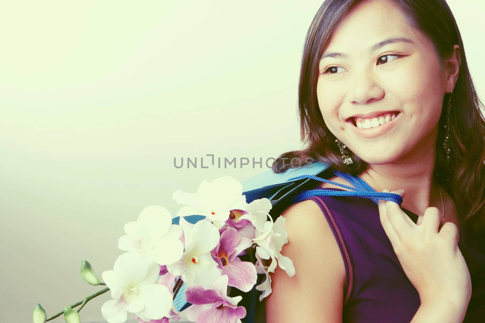 Close-up of a young woman carrying flowers in a shopping bag