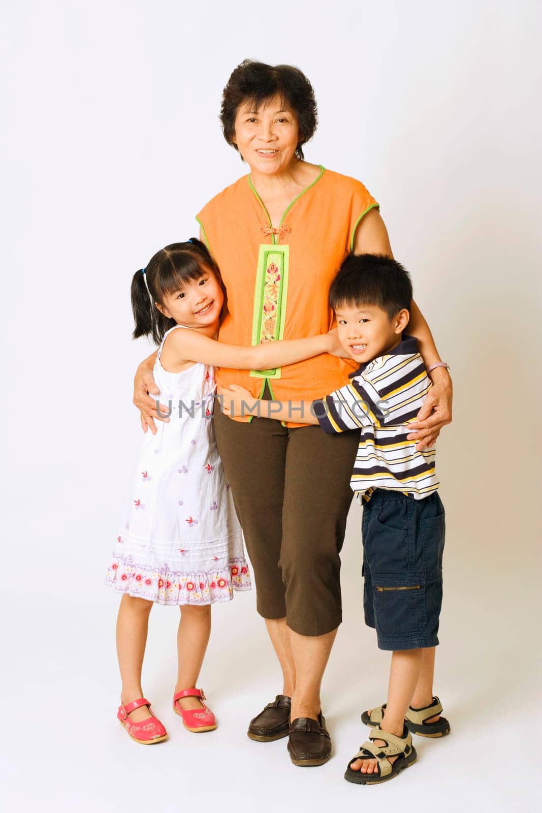 Portrait of a mature woman standing with her grandson and a granddaughter
