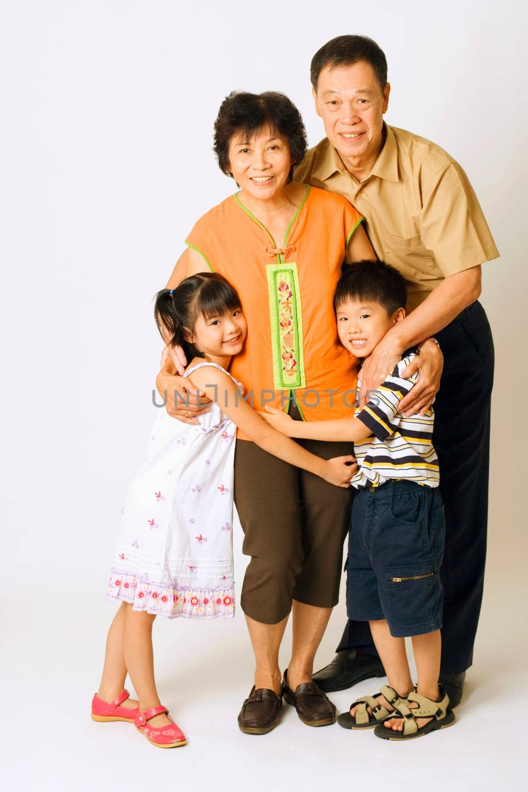 Portrait of a senior man and a mature woman standing with their grandchildren