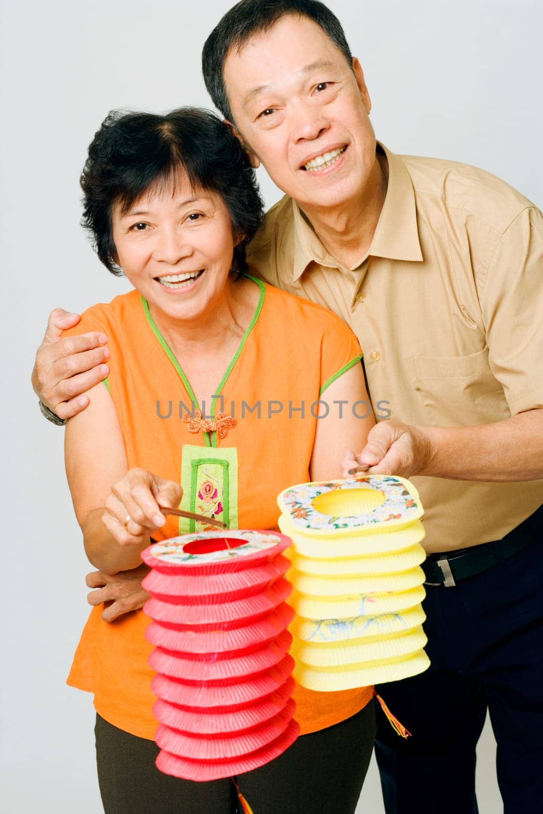 Portrait of a senior man and a mature woman holding Chinese lanterns
