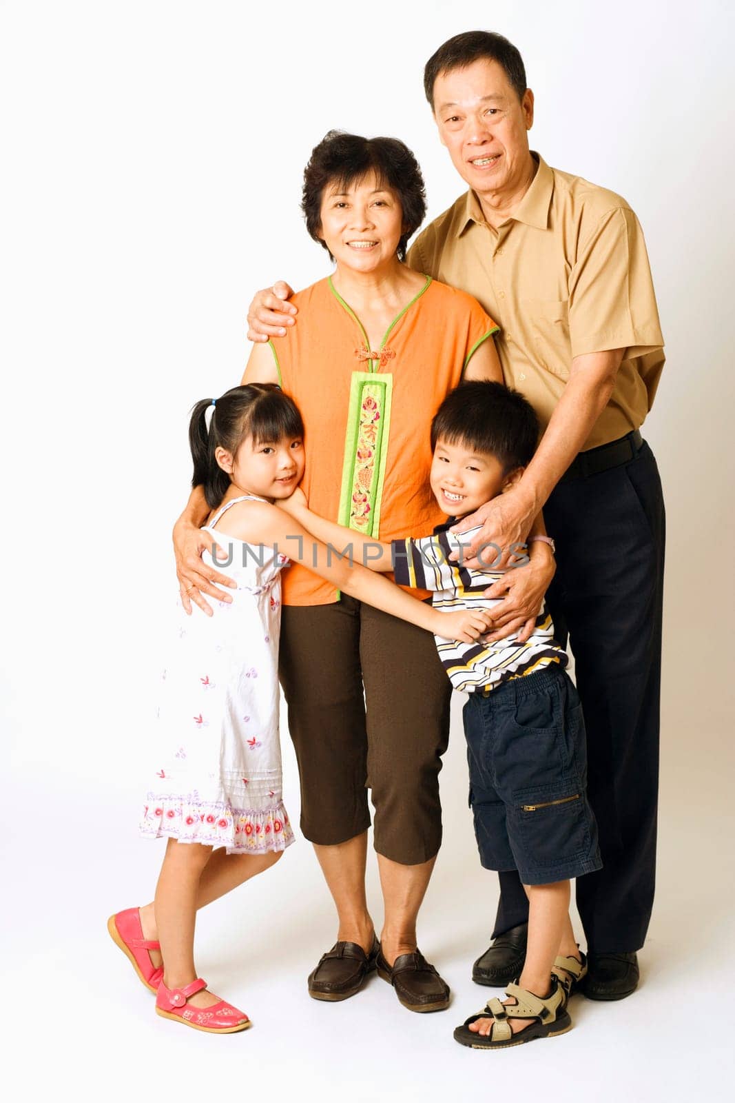 Portrait of a senior man and a mature woman standing with their grandchildren