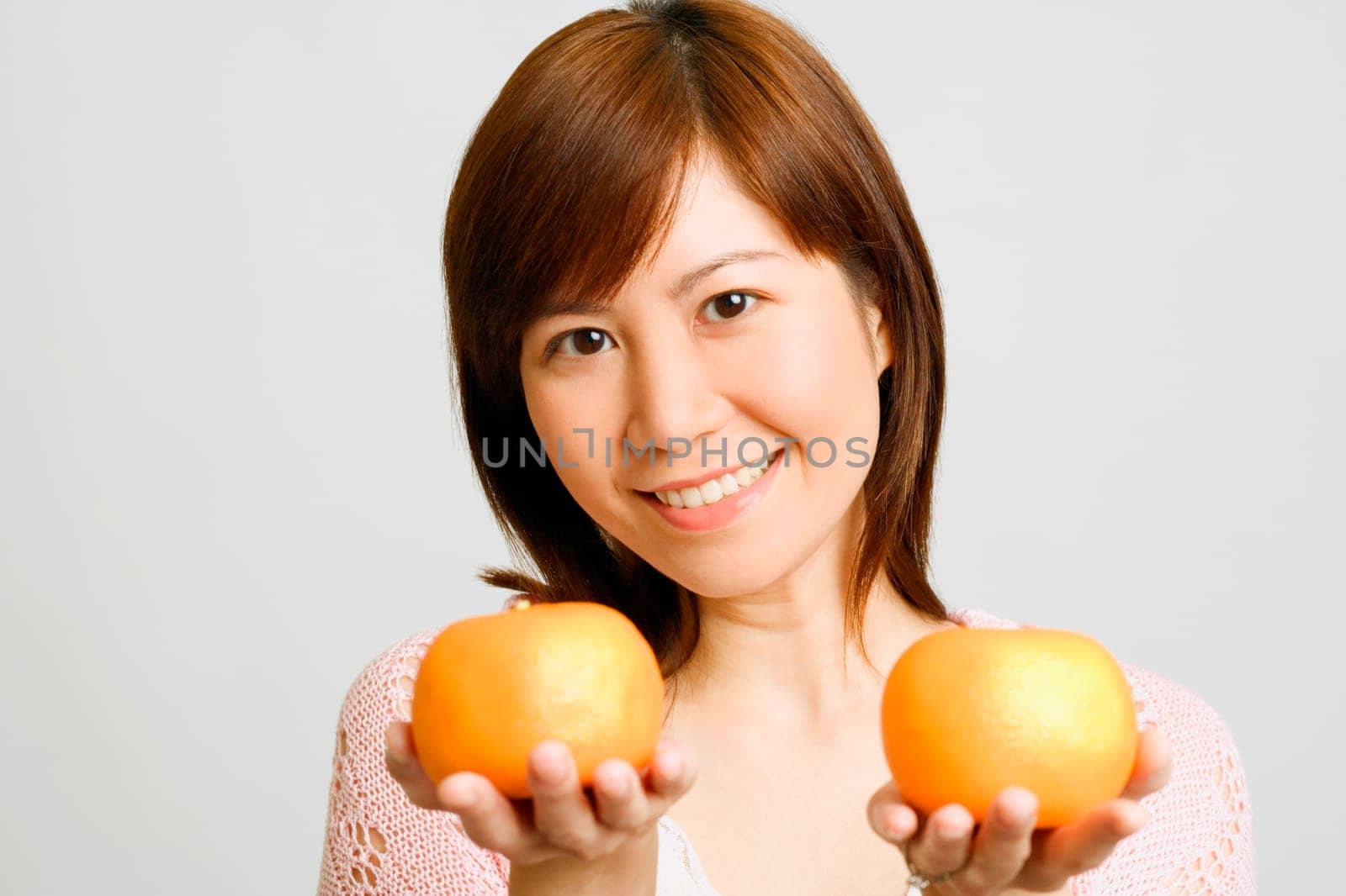 Portrait of a young woman holding oranges