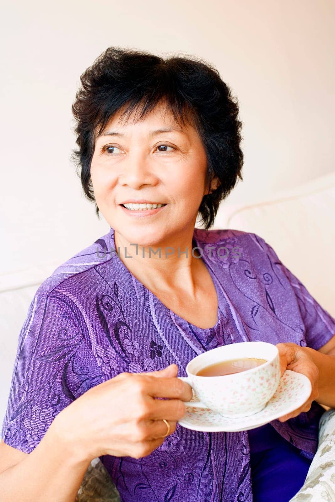 Close-up of a mature woman holding a cup of tea
