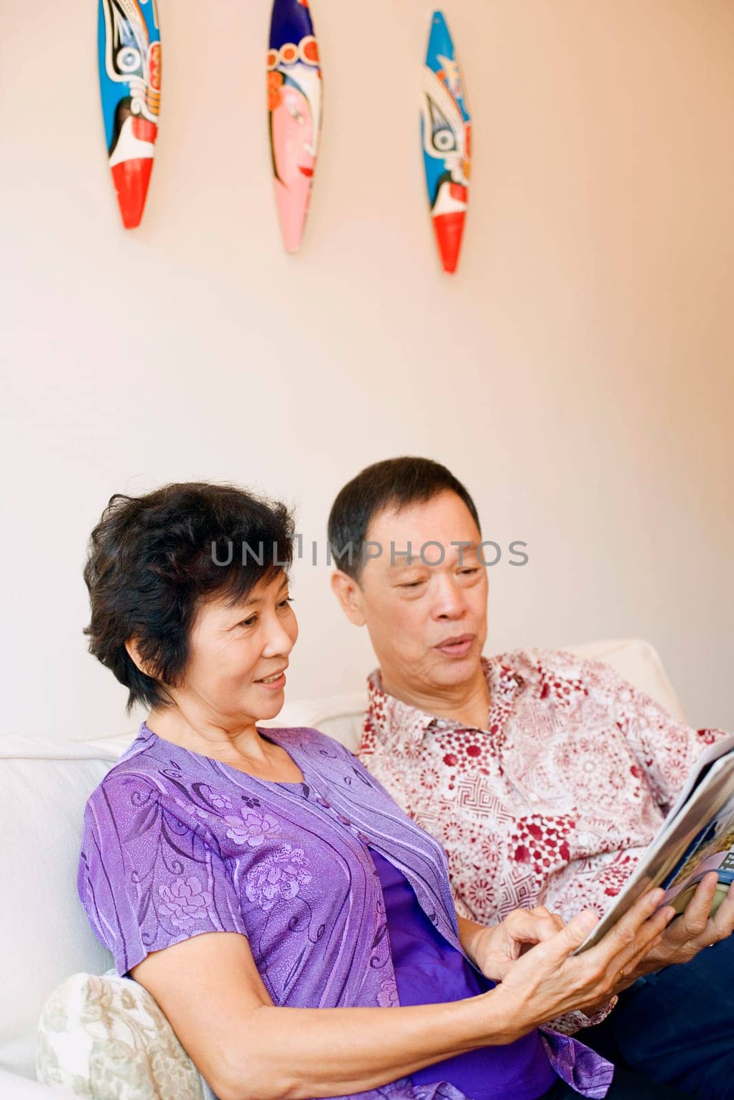 Close-up of a senior man and a mature woman reading a magazine