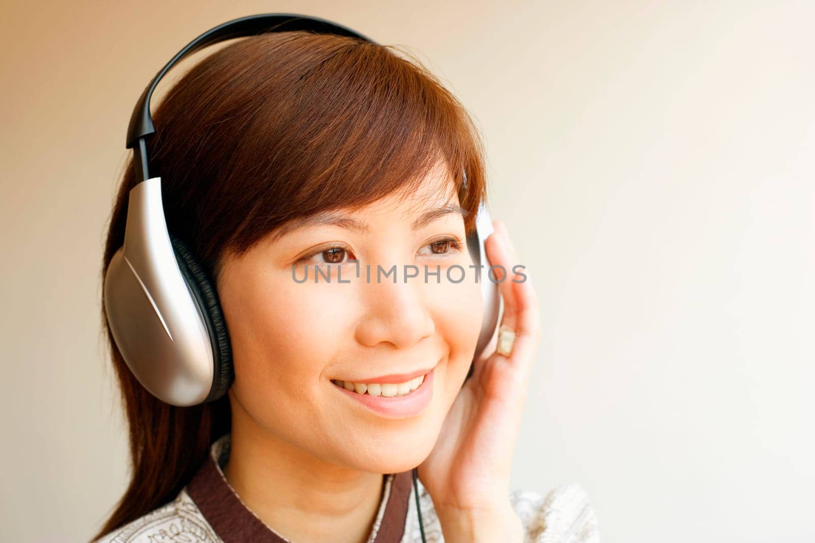 Close-up of a young woman wearing headphones and listening to music