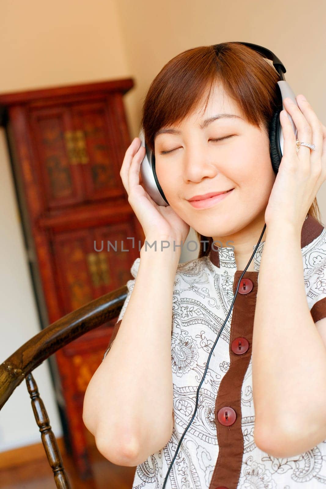 Close-up of a young woman wearing headphones and listening to music