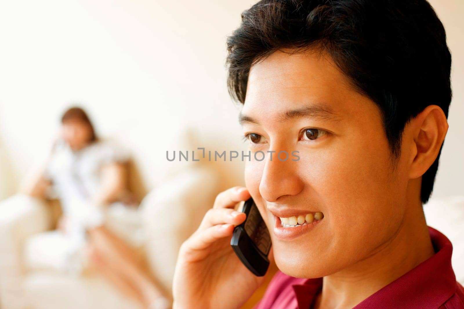 Close-up of a young man talking on a mobile phone and smiling