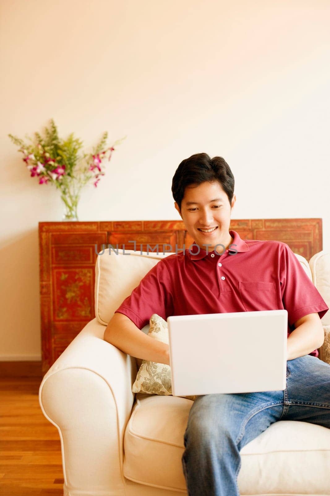 Young man sitting on a couch and using a laptop