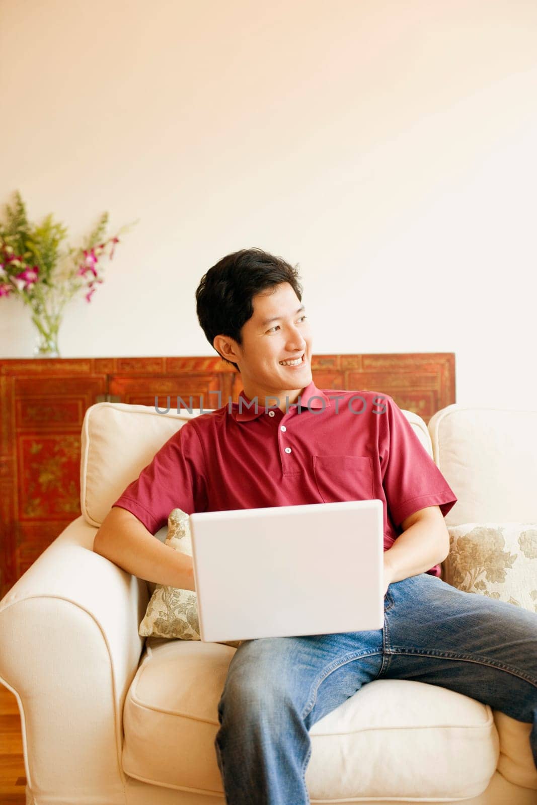 Young man sitting on a couch with a laptop