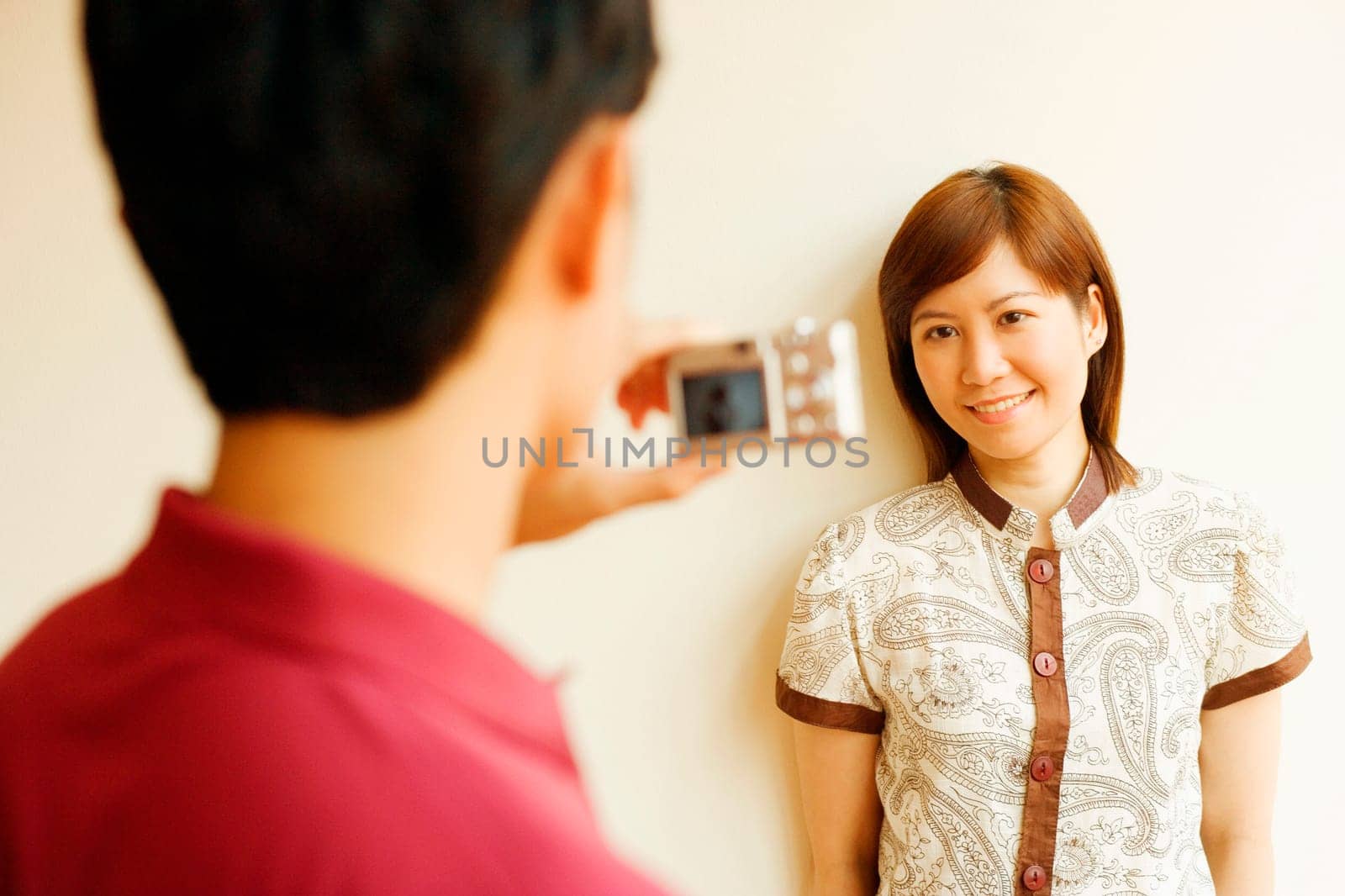 Young man taking a picture of a young woman