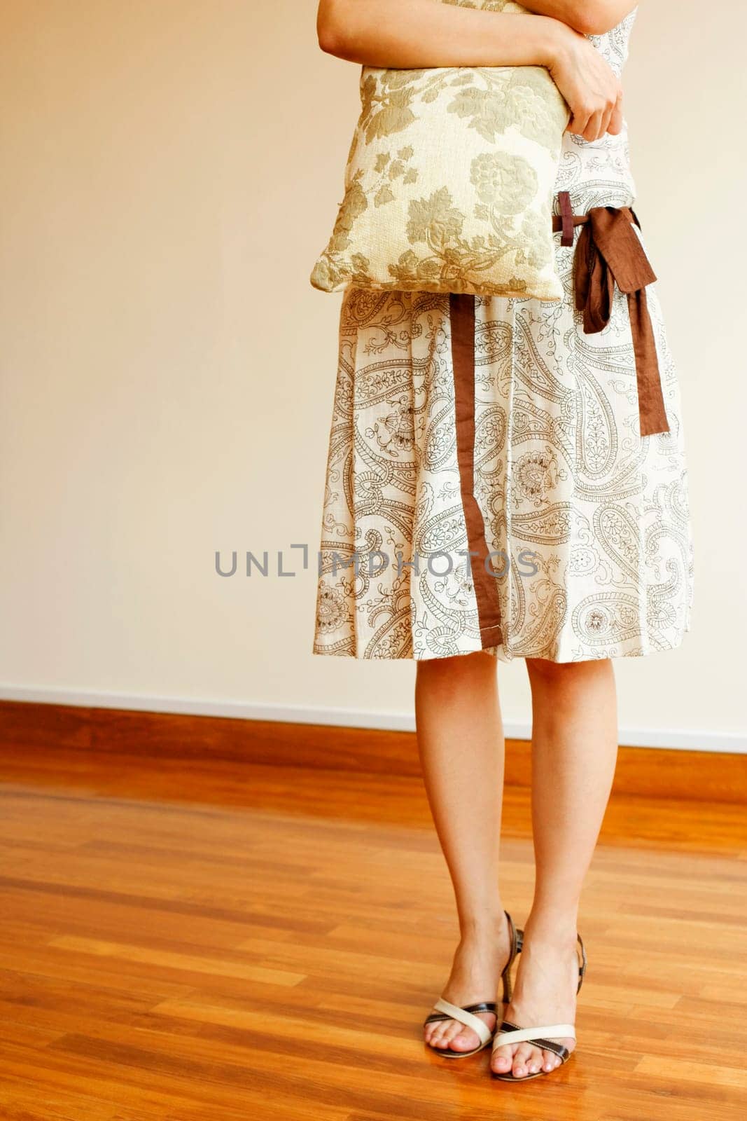 Low section view of a woman holding a pillow