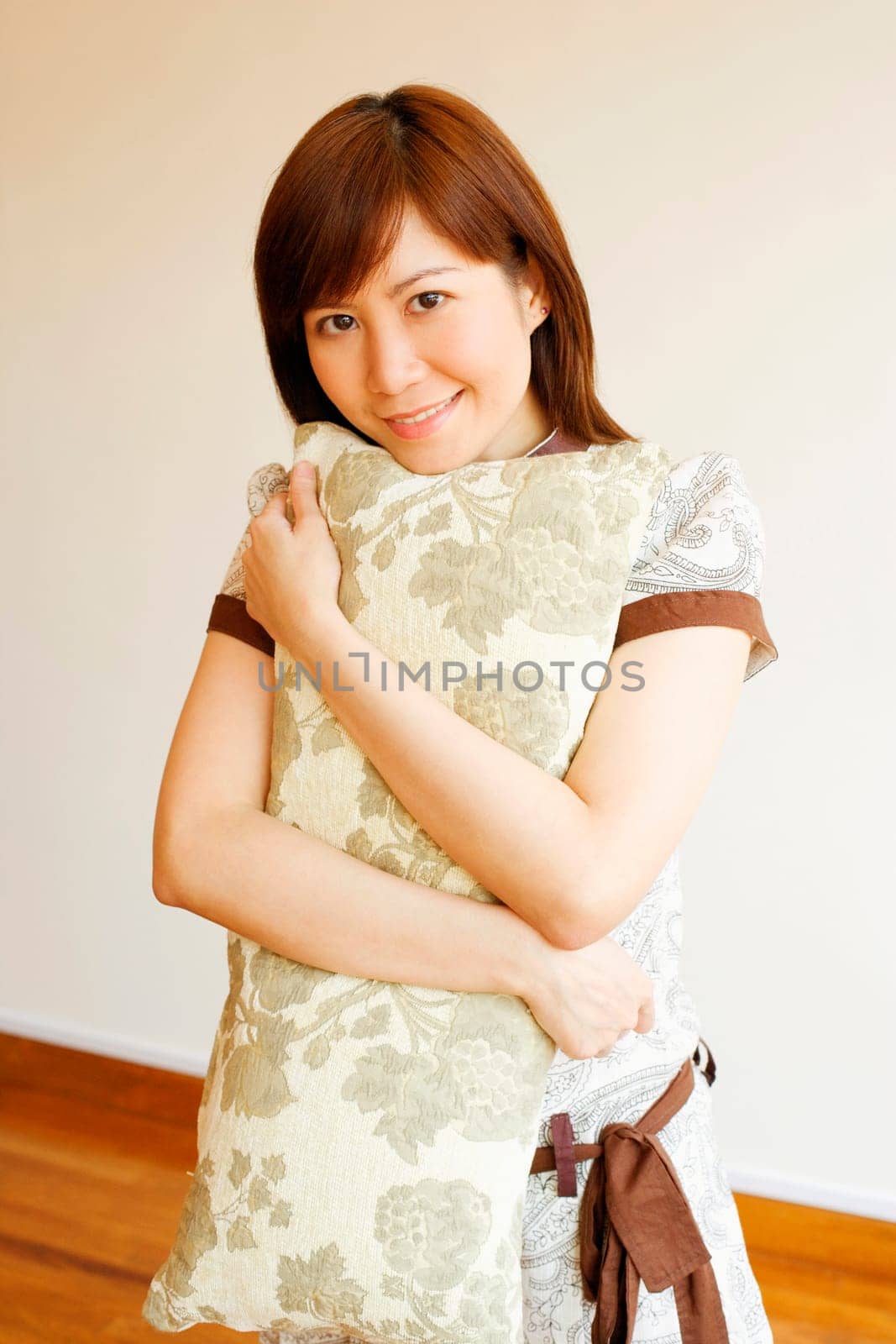 Portrait of a young woman holding a pillow