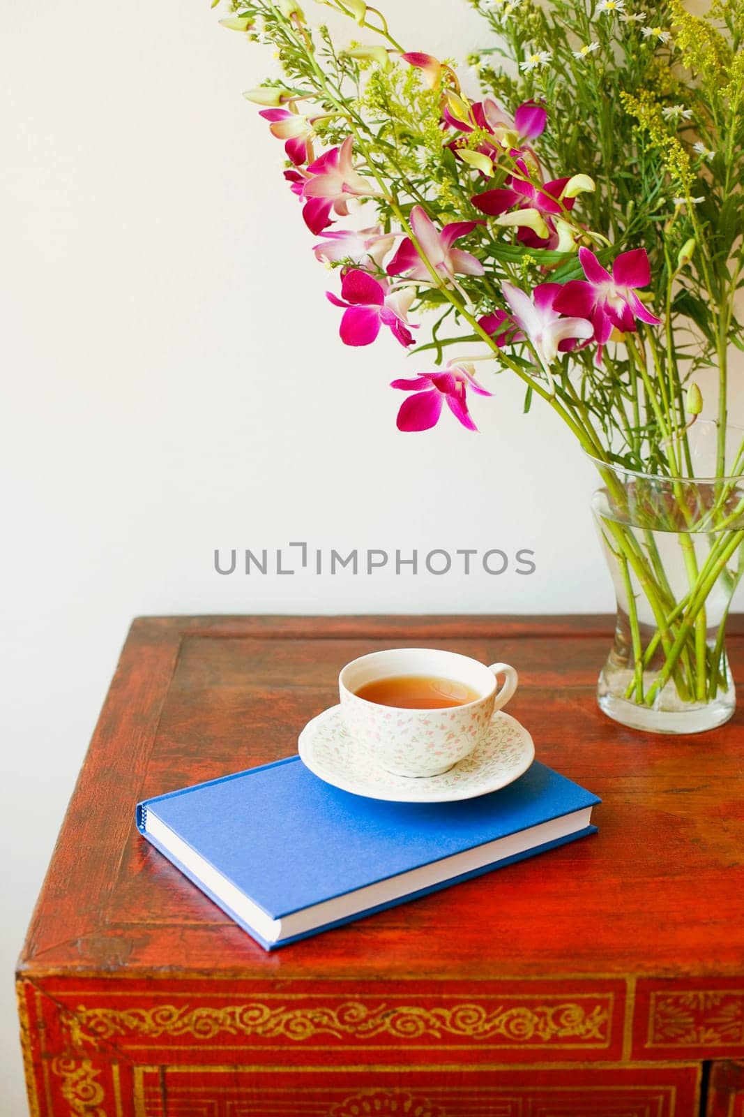 Close-up of a cup on a diary near a vase