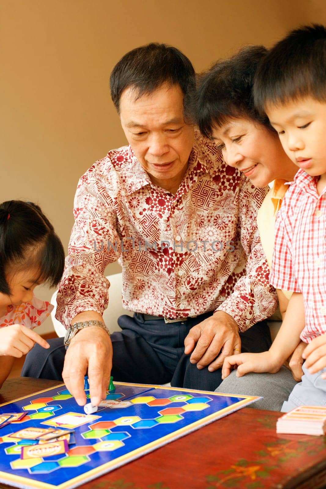 Close-up of a girl and a boy playing a game with their grandparents