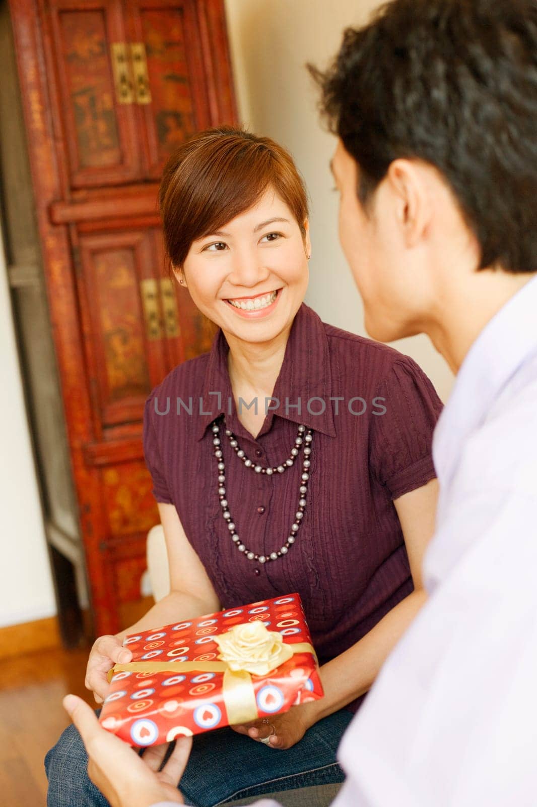 Close-up of a young man giving a gift to a young woman