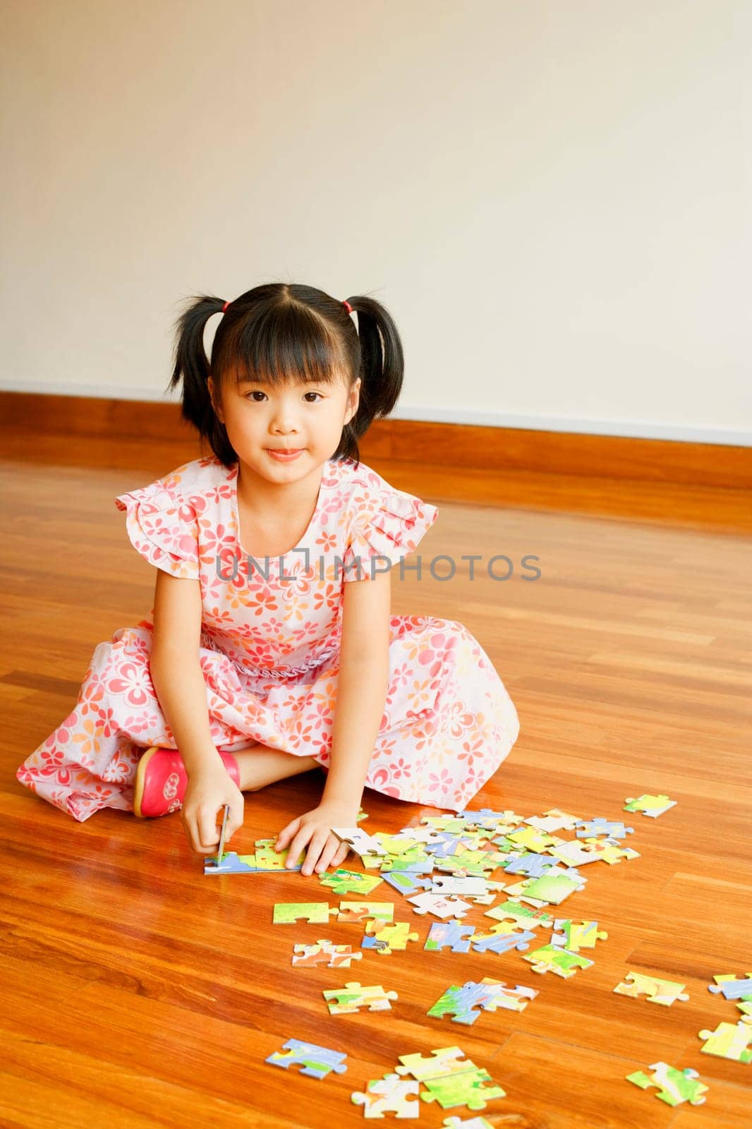 Portrait of a girl playing with a jigsaw puzzle