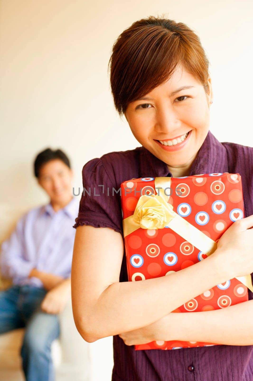 Portrait of a young woman smiling and holding a gift