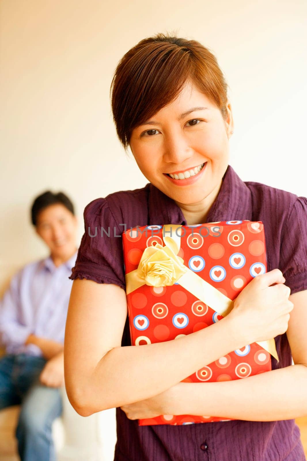Close-up of a young woman smiling and holding a gift