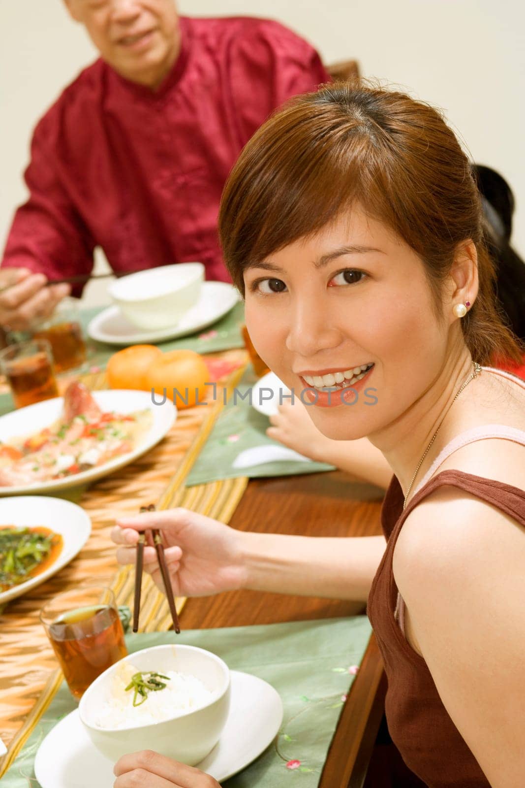 Portrait of a young woman eating with chopsticks