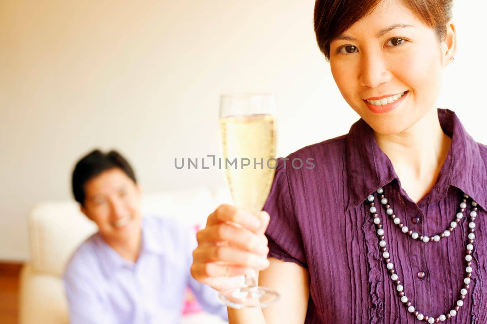 Portrait of a young woman smiling and holding a champagne flute